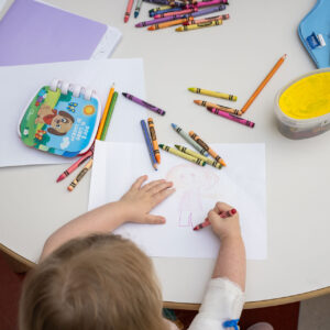 Foto di un bambino ricoverato in ospedale che fa un disegno con i pastelli colorati